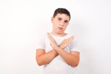 İzole edilmiş arka planda duran günlük kıyafetler giyen genç yakışıklı çocuk. Reddedilme ifadesi olumsuz işaret göndererek el ele tutuşuyor mu?.