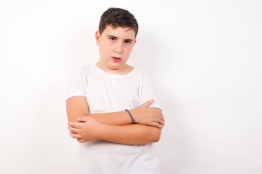 Beyaz tenli, genç, yakışıklı, beyaz erkek portresi, kollarını kavuşturmuş, mutlu ve kendinden emin, günlük kıyafetler giymiş, beyaz arka planda soyutlanmış..