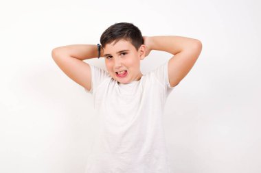 Çekici bir gencin portresi, kendinden emin bir ifadeyle gülümsüyor ve ellerini başının üstünde tutuyordu. Beyaz arkaplanda duruyor. 