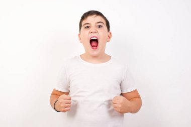 Sıradan kıyafetlerle, kollarını kaldırarak, yumruklarını sıkarak, neşe ve heyecanla golü haykırarak güçlü ve kararlı bir çocuk portresi. Zafer, başarı ve başarı kavramı.