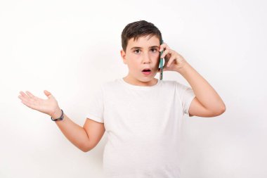 Beyaz arka planda telefonla konuşan genç bir çocuk elleri yüzü asık, utancından şoke olmuş, sinirli ve hayal kırıklığına uğramış bir halde. Hata için korku ve üzüntü. 