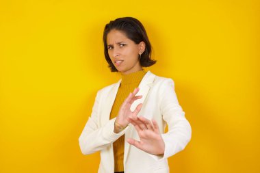 Ne kadar iğrenç! Hoşnutsuz genç bir kadın, rahat giyinmediğini söylüyor ve tatminsiz bir yüz ifadesi takınıyor çünkü arka planda iğrenç ya da iğrenç bir şey görüyor..