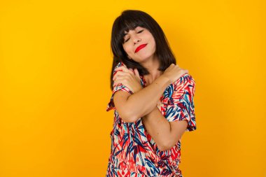 Hoş görünümlü, sevimli, çekici, çekici, büyüleyici, bakımlı, sakin, huzurlu, neşeli, kendine sarılan kızın portresi. 