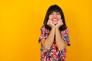 Genç ve güzel beyaz kadın portresi. Günlük giysiler giymiş. Duygularla boğulmuş. Heyecan ve mutluluğu ifade ediyor.