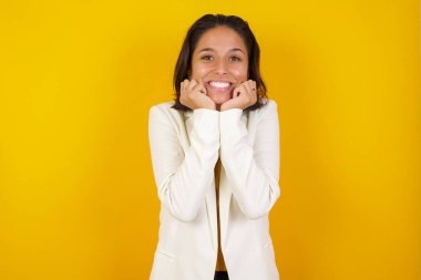 Hayalperest genç Avrupalı kadın ellerini çenesinin altına bastırıyor, mutlu bir ifadeyle bakıyor, dişlek bir gülümsemesi var. 