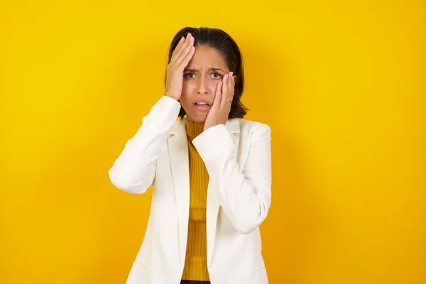 Young gloomy woman, hiding her face with hands pouting and crying, standing upset and depressed complaining to friend about her job problems. Her boyfriend forgot about anniversary