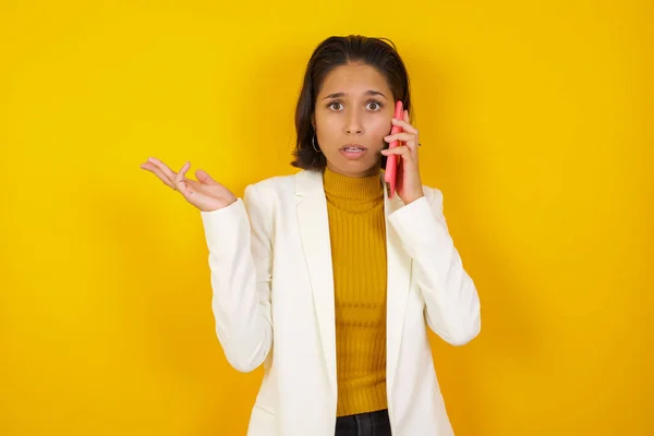 Jonge Zakenvrouw Staat Tegen Een Gele Achtergrond Praten Aan Telefoon — Stockfoto