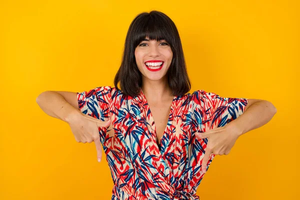 Jovem Bela Mulher Morena Vestido Colorido Apontando Para Baixo Fundo — Fotografia de Stock