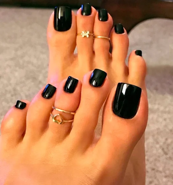 Toes with rings and nail Polish