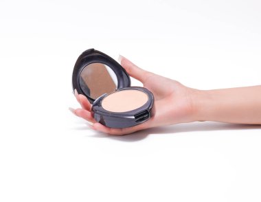 Kadın elinde ayna ile temel pudrası tutuyor..