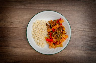 Pirinç ve salata tabağı ile lezzetli pirinç ve sebzeler ahşap arka planda, üst manzara