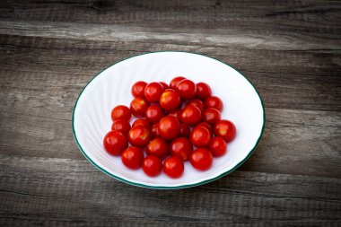 Küçük kırmızı kiraz domatesleri grup besin renginde bir tabakta
