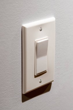 Beyaz duvardaki aydınlatma düğmesi.