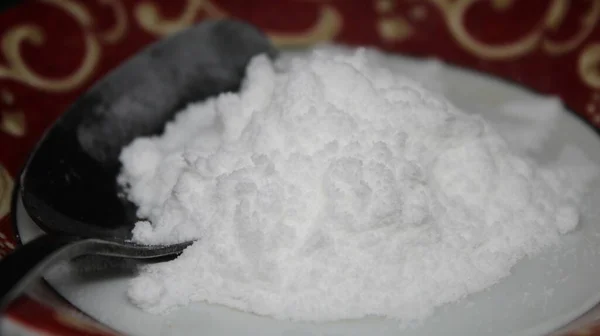 Siyah Arka Planı Olan Bir Tabakta Pudra Şekeri Kaşık — Stok fotoğraf