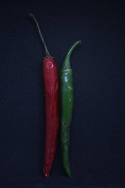 Siyah arka planda yeşil ve kırmızı biber.