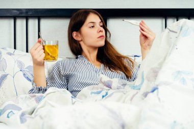 Grip belirtileri ile yatakta yatan genç kadın