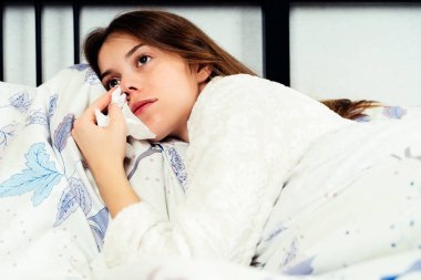 Genç kadın yatakta tek başına yatarken ve ağlıyor