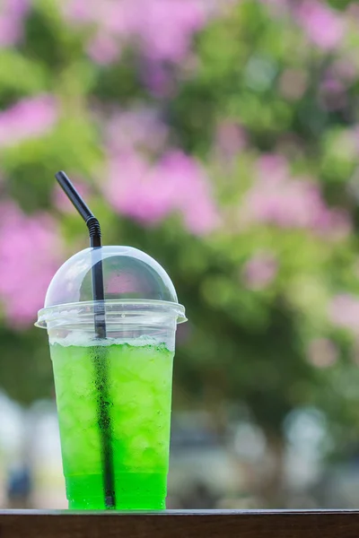 Зеленая сода в чашке на фоне природы — стоковое фото