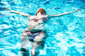 Boldog nő élvezi a medence lebeg a hátán
