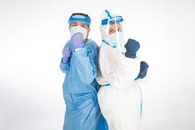 PPE giyen bir adam ve kadın doktor beyaz arka planda koronavirüsle savaşmak için PPE giyiyorlar. Savaşçı. COVID tıp konsepti