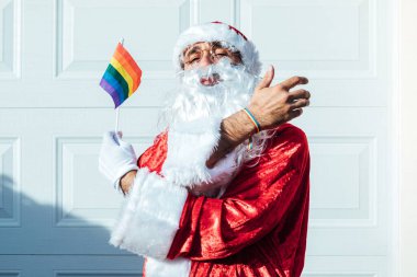 LGBT gökkuşağı bayrağı ve bileziği olan Noel Baba