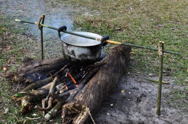 Açık doğa tencereye kullanarak pirinç pişirme. Kuru odun ve kullanım taş ocağı stand kullanarak bir ateşte pişirme gıda Camping.