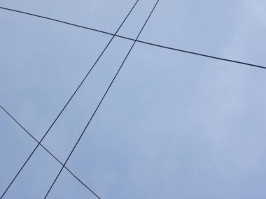 Mavi gökyüzü arkaplanındaki elektrik kabloları