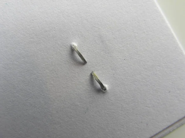 Beyaz kağıdın arkasındaki zımba.