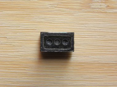 Akıllı telefonun küçük hoparlör mikro bileşeni ahşap masada tutulur