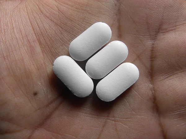 Malý Podlouhlý Tvar Bílé Medicíny Pilulky Dlani Ruky — Stock fotografie