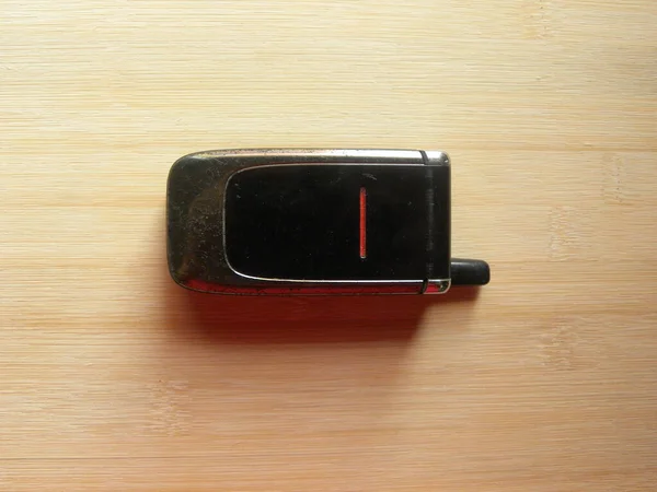Stary Czarny Kolor Flip Telefon Trzymany Drewnianym Stole — Zdjęcie stockowe