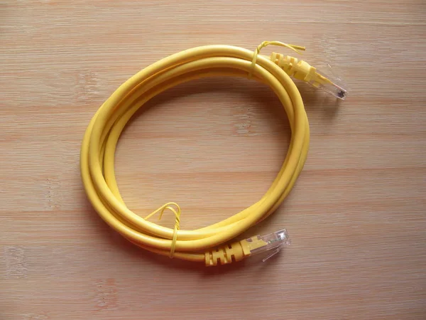 木制桌子上的黄色宽带电缆千斤顶 — 图库照片