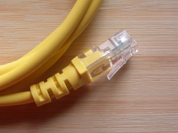 Yellow broadband cable jack kept on wooden table