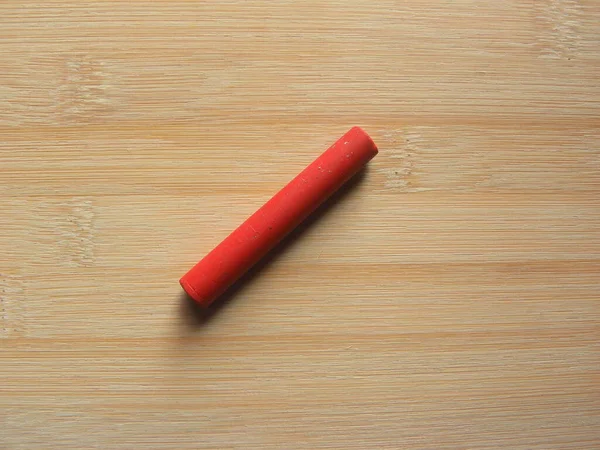Czerwony Olej Pastelowy Kij Trzymany Drewnianym Stole — Zdjęcie stockowe