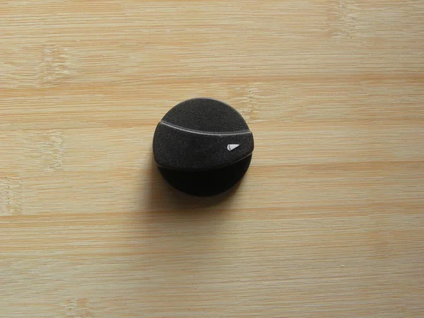 Siyah Renkli Plastik Ocağın Kapalı Düğmesi Ahşap Masada Duruyor — Stok fotoğraf
