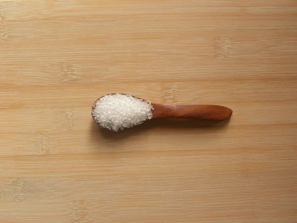 木のスプーンで白い色の一般的な洗練された砂糖 — ストック写真