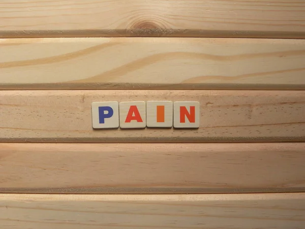 木材背景的单词疼痛 — 图库照片