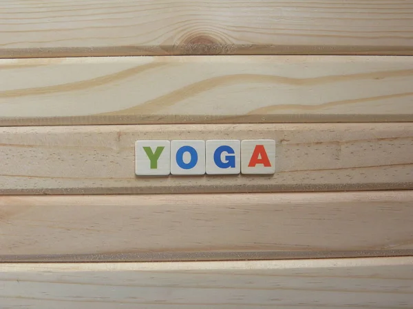 Word Yoga on wood background