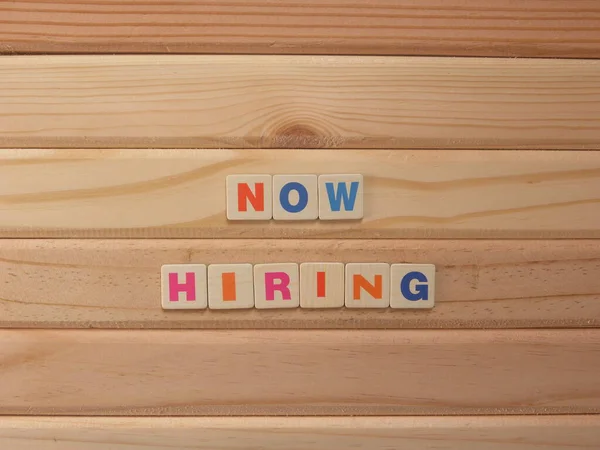 Word Now Hiring on wood background