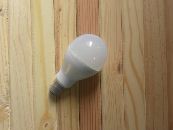 White color LED light bulb kept on wooden table