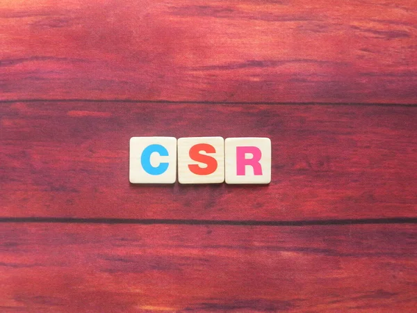 Abbreviation CSR (Corporate Social Responsibility) on wood background