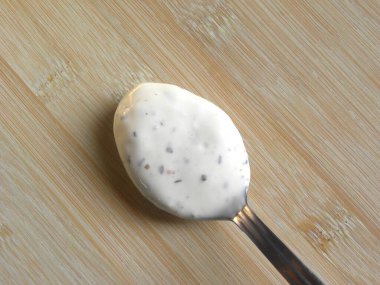 Paslanmaz çelik kaşıkta beyaz renkli makarna sosu