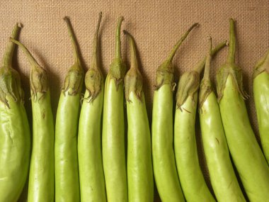 Uzun, çiğ, yeşil patlıcan rengi.