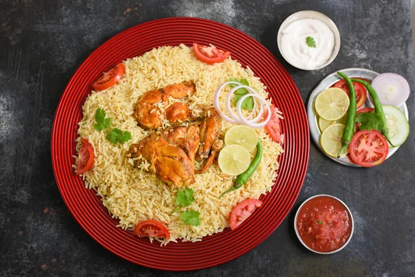 Kuzhimanthi veya baharatlı Manthi Arap tavuğu Biryani et pişirdi, Güney Hindistan 'ın Malabar Kerala kentinde kırmızı tabakta baharatlı Basmati pilavı. Sebzesiz Hint yemeklerinin en üst görüntüsü.