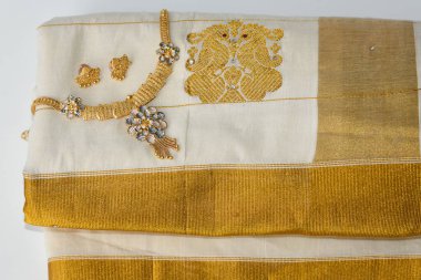 Hint ipeği sarisi, el yapımı beyaz Kerala Sari ve altın süsler, mücevherler. Kadınlar bu geleneksel giysiyi Onam festivali Vishu 'da kullanır, Hindistan' da düğün. çok renkli sari elbiseler.