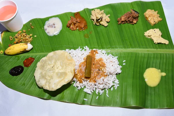 Onam sadhya, geleneksel Hint yemeği haşlanmış pirinç yeşil muz yaprağında servis ediliyor baharatlı sıcak köri ve Hindistan 'daki Kerala hasat festivali için bolca tatlı tatlı var.. 