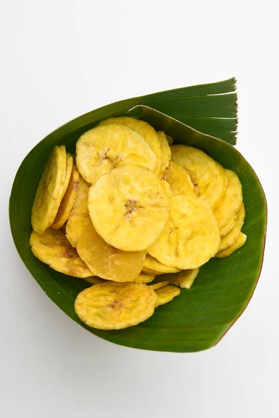 Kerala snack Banana chips or Kaya Varuthathu fried snack in banana leaf on white background popular in South India Tamil Nadu, Top view Indian tea time food fried in coconut oil.