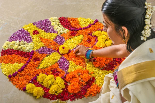 Kerala Onam festivali çiçek yatağı, Pookalam dekorasyonu yapan kadın Onam 'da kusursuz tropikal çiçek deseni, Kerala, Hindistan' da Vishu kutlaması. Hint festivali Diwali.