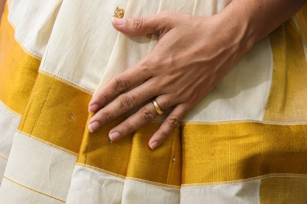 Hint ipeği sarisi, el yapımı beyaz Kerala Sari ve altın süsler, mücevherler. Kadınlar bu geleneksel giysiyi Onam festivali Vishu 'da kullanır, Hindistan' da düğün. çok renkli sari elbiseler.