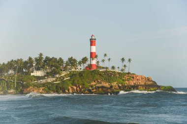 Kerala, India - September 08, 2019 : Kovalam beach and Vizhinjam light house. Sea waves moving towards the shore. clipart